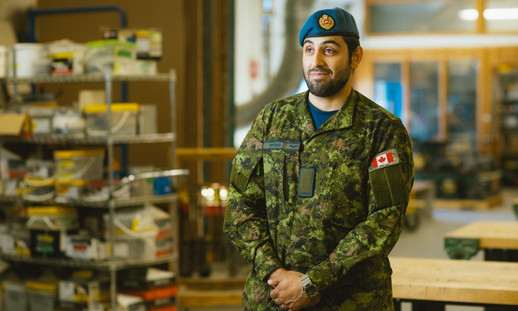 A person wearing a military uniform standing in a workshop.