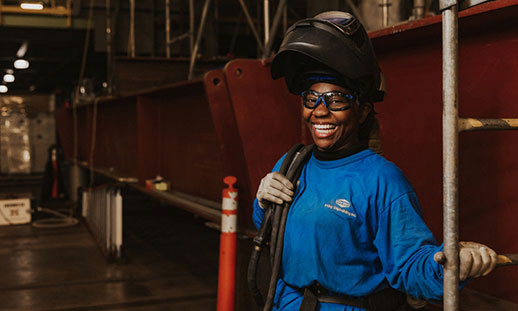 Woman wearing wielding mask in shipyard building