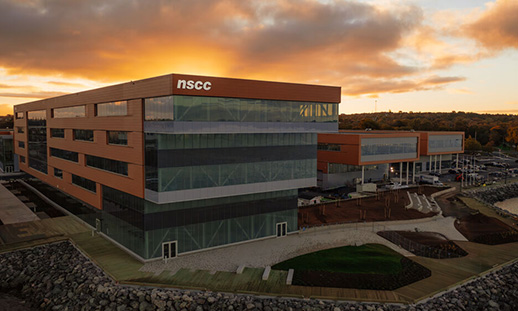 An aerial photo of a large building on the water.