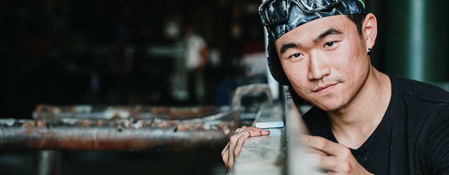 Male student in a welding suit working. 