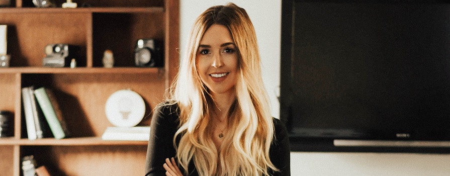 A blonde woman smiles at the camera.