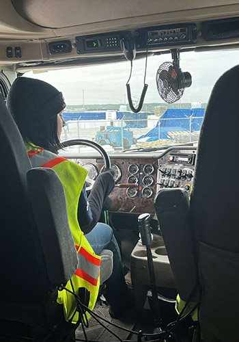 A shot from over Ellen's shoulder as she drives a big rig.