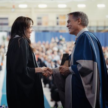 Don Bureaux presenting a student with diploma at convocation