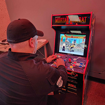 Someone playing an arcade machine at the Esports Lounge.