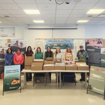 Students stand by a display of the products they developed for a non-profit.