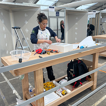 A person standing at a workbench taking part in a competition.
