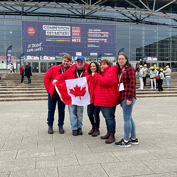 A group of people holding a Canadian flag.