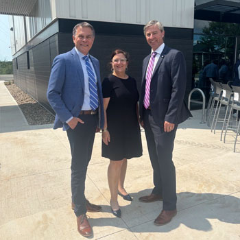 Three people stand for a photo outside NSCC Pictou Campus.