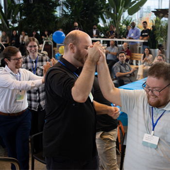Image shows a team celebrating after learning that they won a competition.
