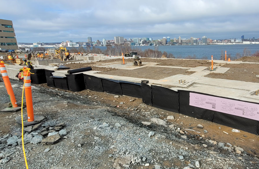 The foundation at an outdoor construction site near the ocean is freshly poured.