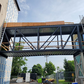 A pedway, connecting a student housing facility to the campus is shown under construction.