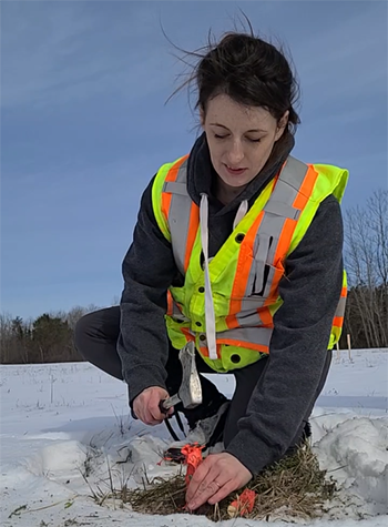 Kailey hammers a metal spike into the ground