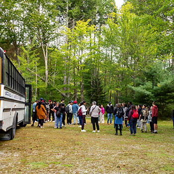 Students gathering alongside a parked bus
