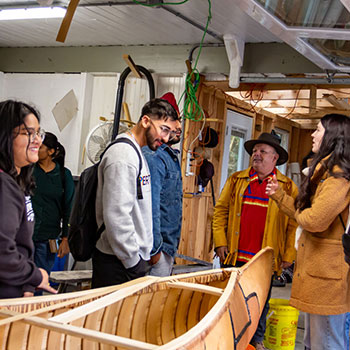 Students exploring a canoe that was made from birch bark