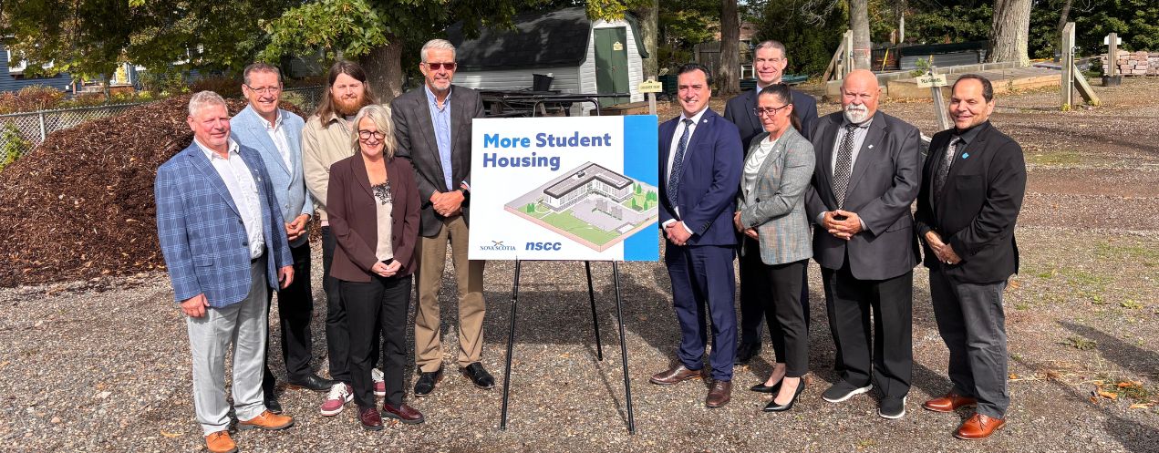 Image of ten individuals from NSCC Kingstec Campus and the Nova Scotia Government standing in front of the future home of new student housing at Kingstec Campus.