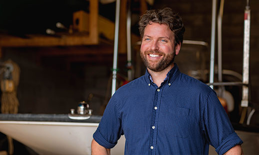 Nathan Crowell, a researcher with  NSCC’s Applied Geomatics Research Group, smiles in a blue, button-up shirt and looks off to the left.