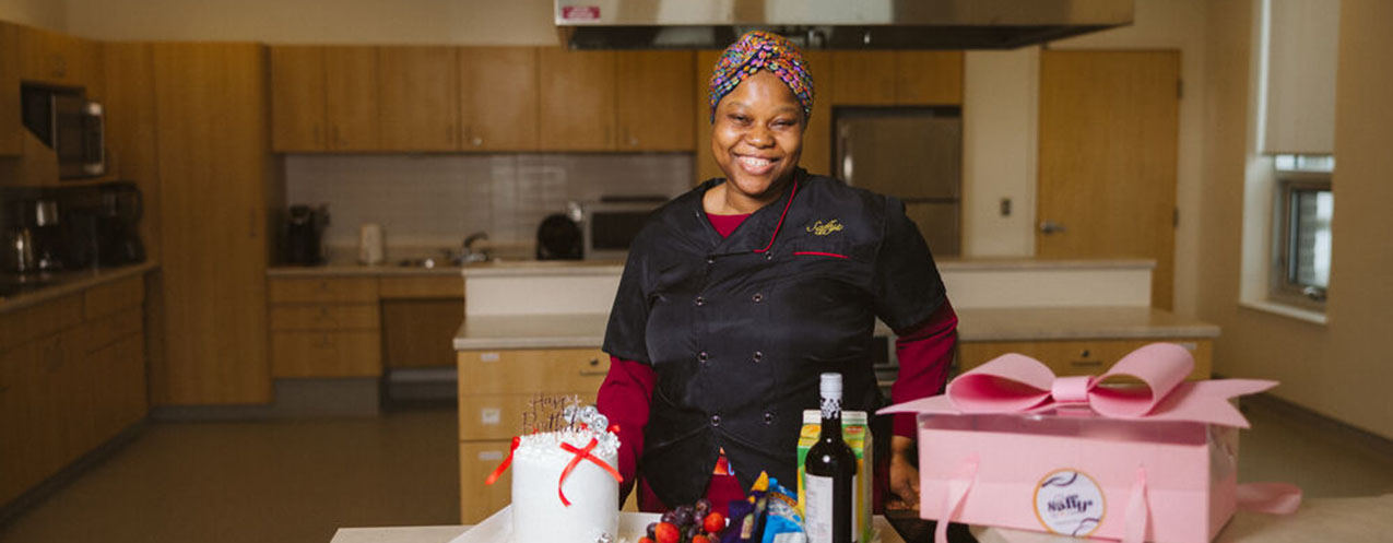 A person standing in a kitchen, with food on the counter.