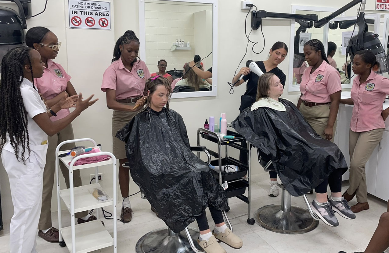 Cosmetology students are practicing their hair drying skills on classmates.
