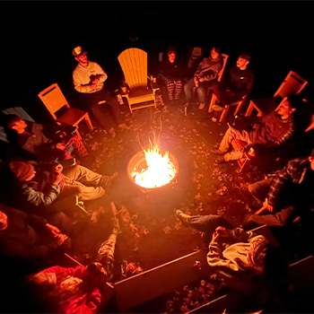 Students sitting around bonfire