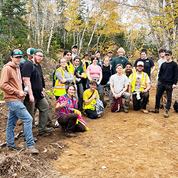 NRET students gather together for a photo with trees in the background