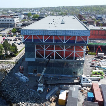 A drone view shows a new portion of a building under construction near the ocean in Cape Breton.