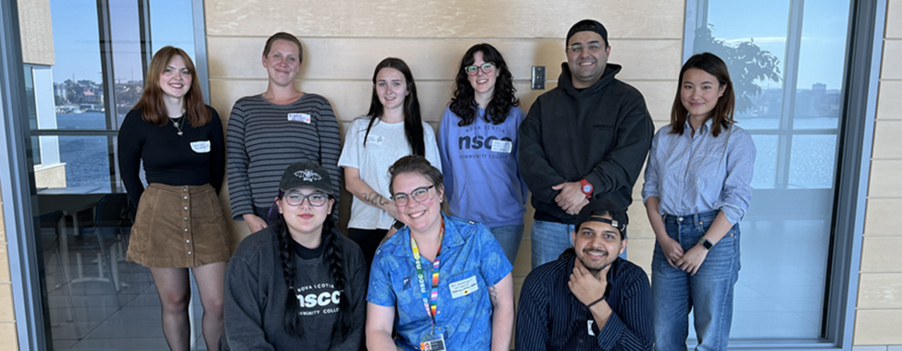 A group of people standing together, smiling. 