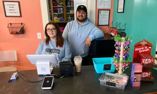 Kelsey Woodland, left, and Jayden Green stand behind the counter of the new Electric Candy shop the partners recently opened on Plummer Avenue in downtown New Waterford. CONTRIBUTED