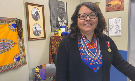 A person is standing in a classroom wearing a medal they were just awarded.