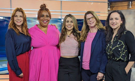 Five people stand together for a photo.