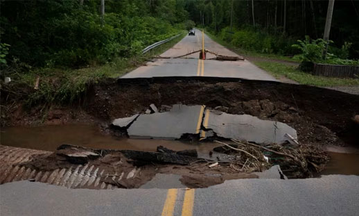 Photo shows road that has been destroyed by recent flooding.
