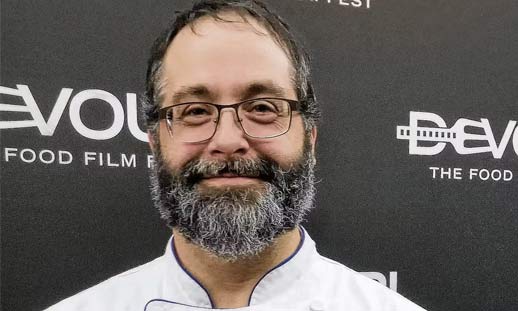 A chef is smiling at the camera.