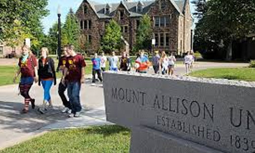 Students walk in front of Mount Allison University sign.