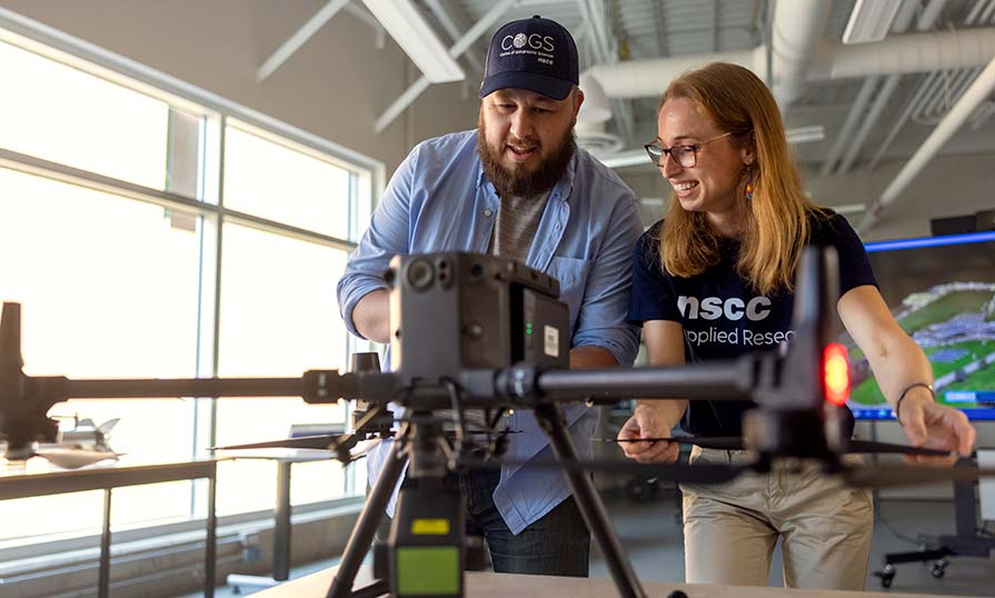 Keith Cusson, an NSCC graduate certificate program grad, works with a colleague on a large drone.