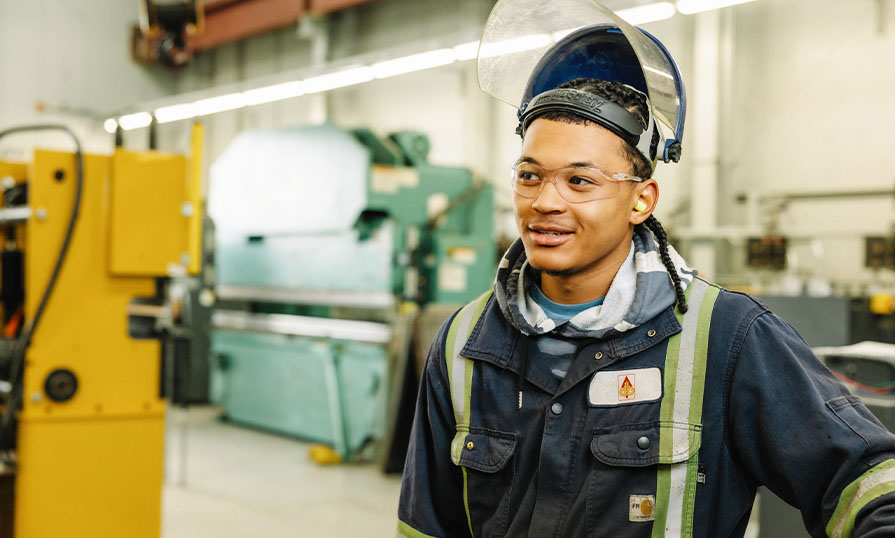 Student in a welding shop wearing safety gear