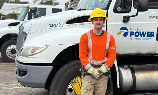 Trainee line technician beside a utility truck during training.