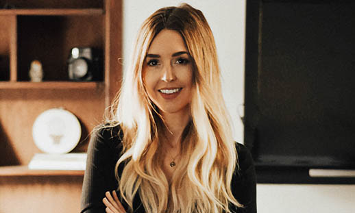 A blonde woman smiles at the camera.