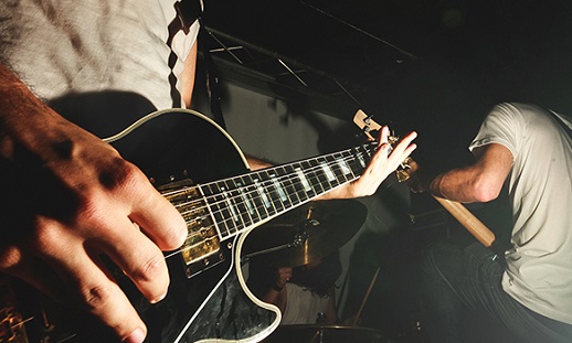 Hands playing a guitar.