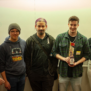 Three people holding an award.