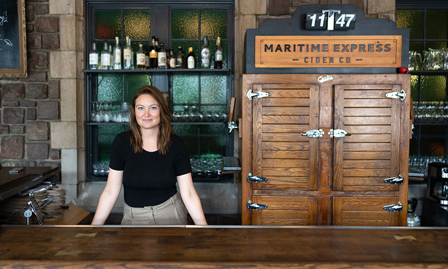 Genevieve Allen-Hearn is pictured. She is standing behind the par at Maritime Express Cider.