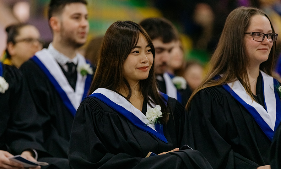 Two female graduates smiling during Convocation.