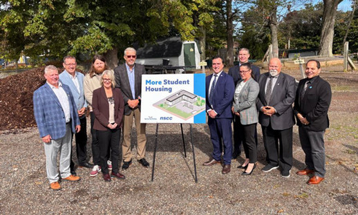 Image of ten individuals from NSCC Kingstec Campus and the Nova Scotia Government standing in front of the future home of new student housing at Kingstec Campus.