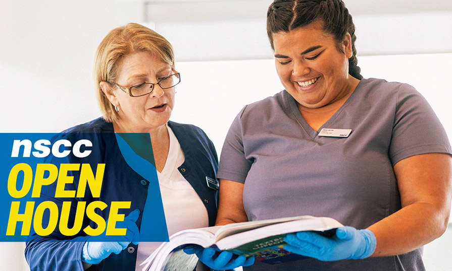 Two women in scrubs examine an open folder.