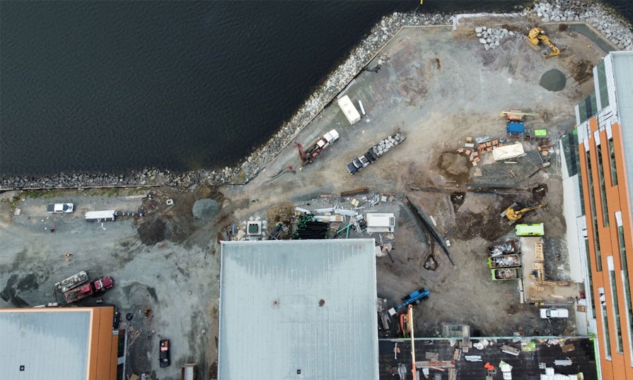 Photo shows a building on the waterfront that is under construction.