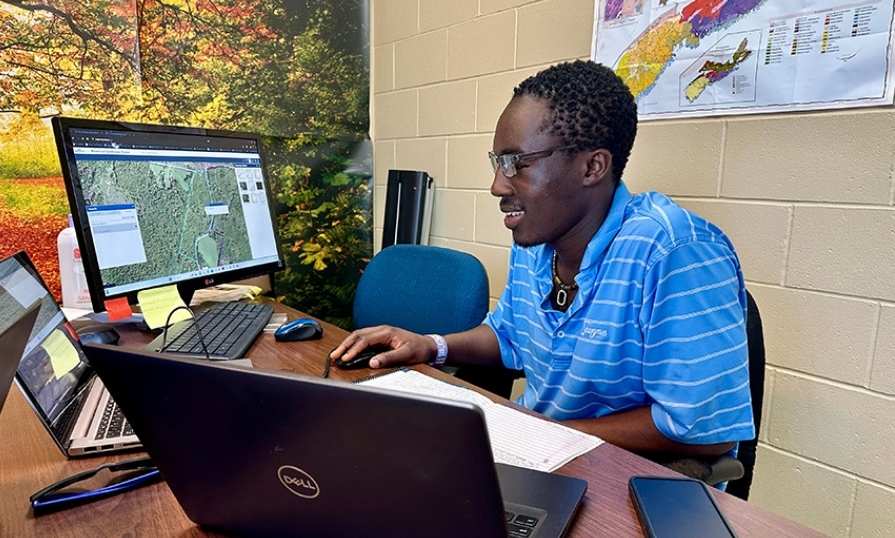 Victor Opadele uses mapping software on a computer.