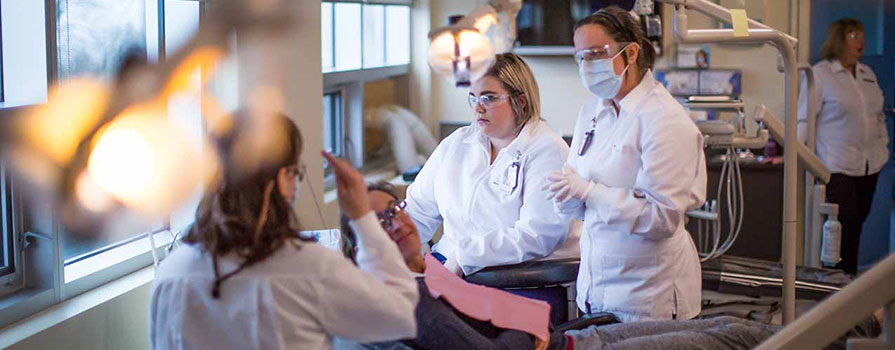 Faculty in the Dental Assisting program are seen teaching students in a dental lab classroom setting. 