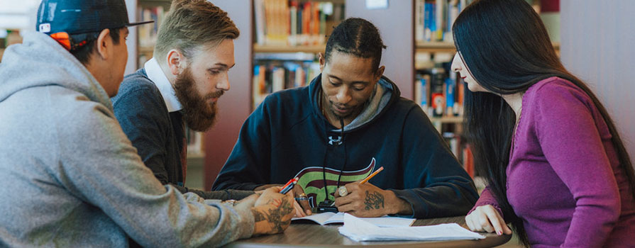 three students studying at a table. 