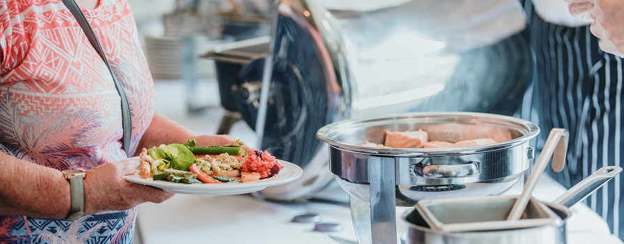 Woman holding a plate of food at a buffet