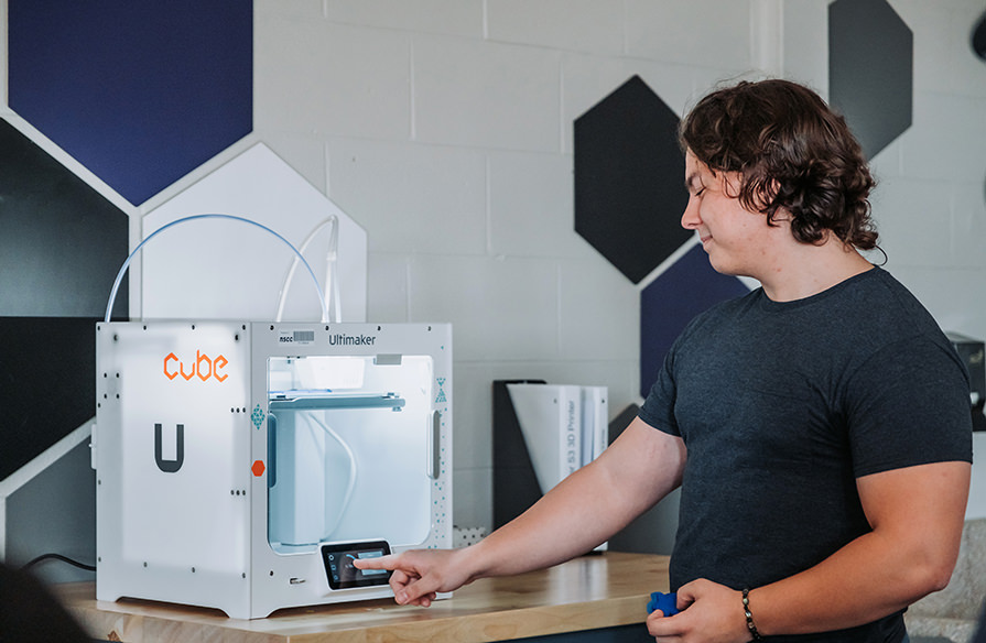 Picture of a student in front of a piece of advanced technology. 