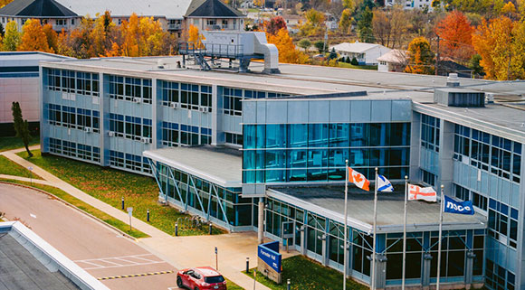 A photo of the exterior of Truro Campus amongst colourful trees in fall.