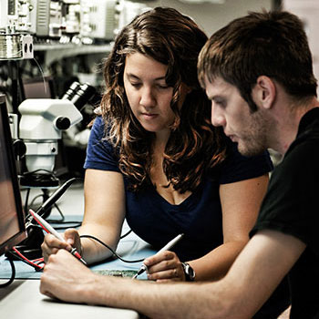 Two students sit together and use new technology in their studies.